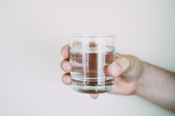 someone holding a glass of water
