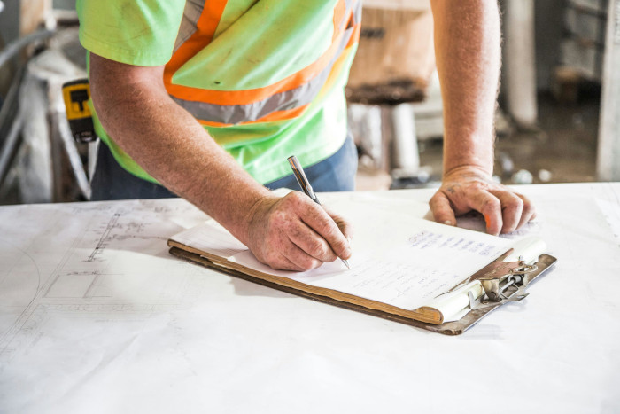 plumber filling out checklist on clipboard